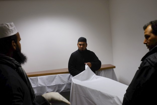 1. Haji Taslim employees prepare shrouding in the ground floor of the East London Mosque for a coffin headed to Cyprus. / 2. Habiba Taslim covers a Harley Davidson hearse with a white cloth.