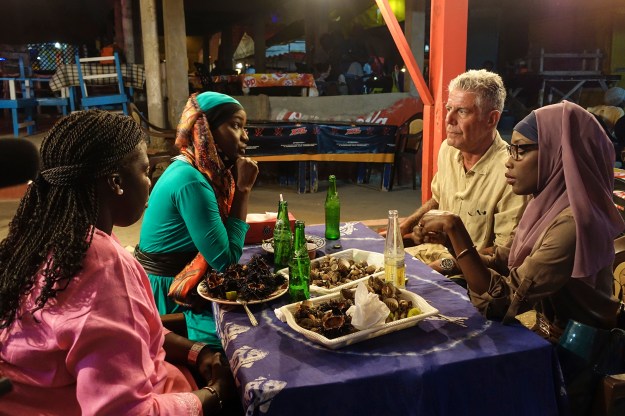 1. Bourdain with Oumy N'Dour, Fama Mouf, and Minielle Tall at Vitres de Sokone in Dakar / 2. Dinner on the beach