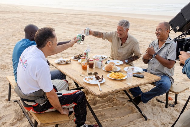 1. Bourdain with Oumy N'Dour, Fama Mouf, and Minielle Tall at Vitres de Sokone in Dakar / 2. Dinner on the beach