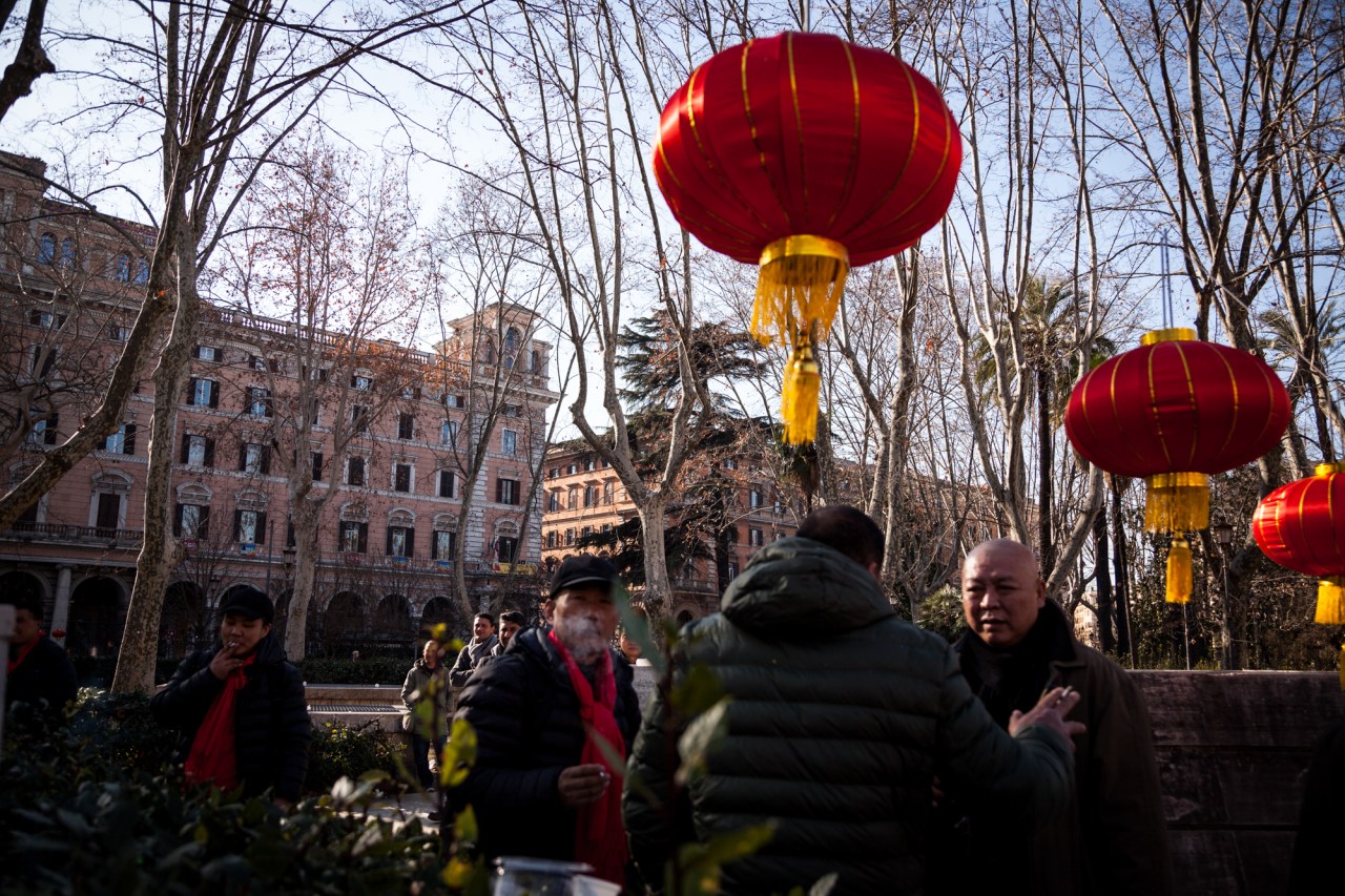 Men take a cigarette break during Chinese New Year celebrations in Piazza Vittorio.
