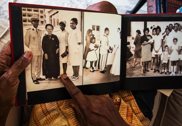 1. Jean Gomis in his kitchen in Dakar. / 2. Gomis points to a picture of himself with his mother, wife, and sister.