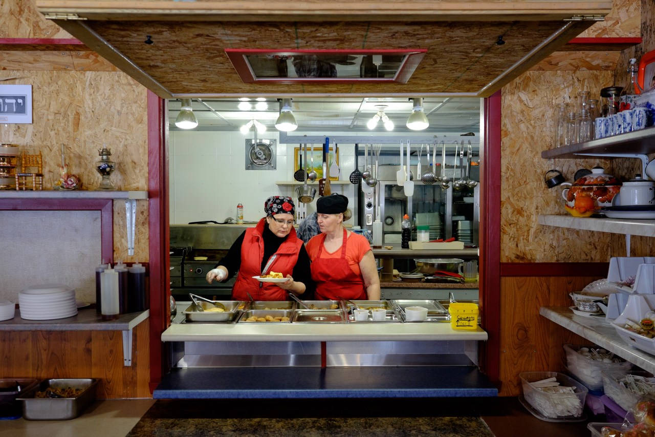 Simone Vezina (left) serves food in her sugar shack in Saint-Modeste, Québec . Popular items are pancakes, sausages, and maple syrup.