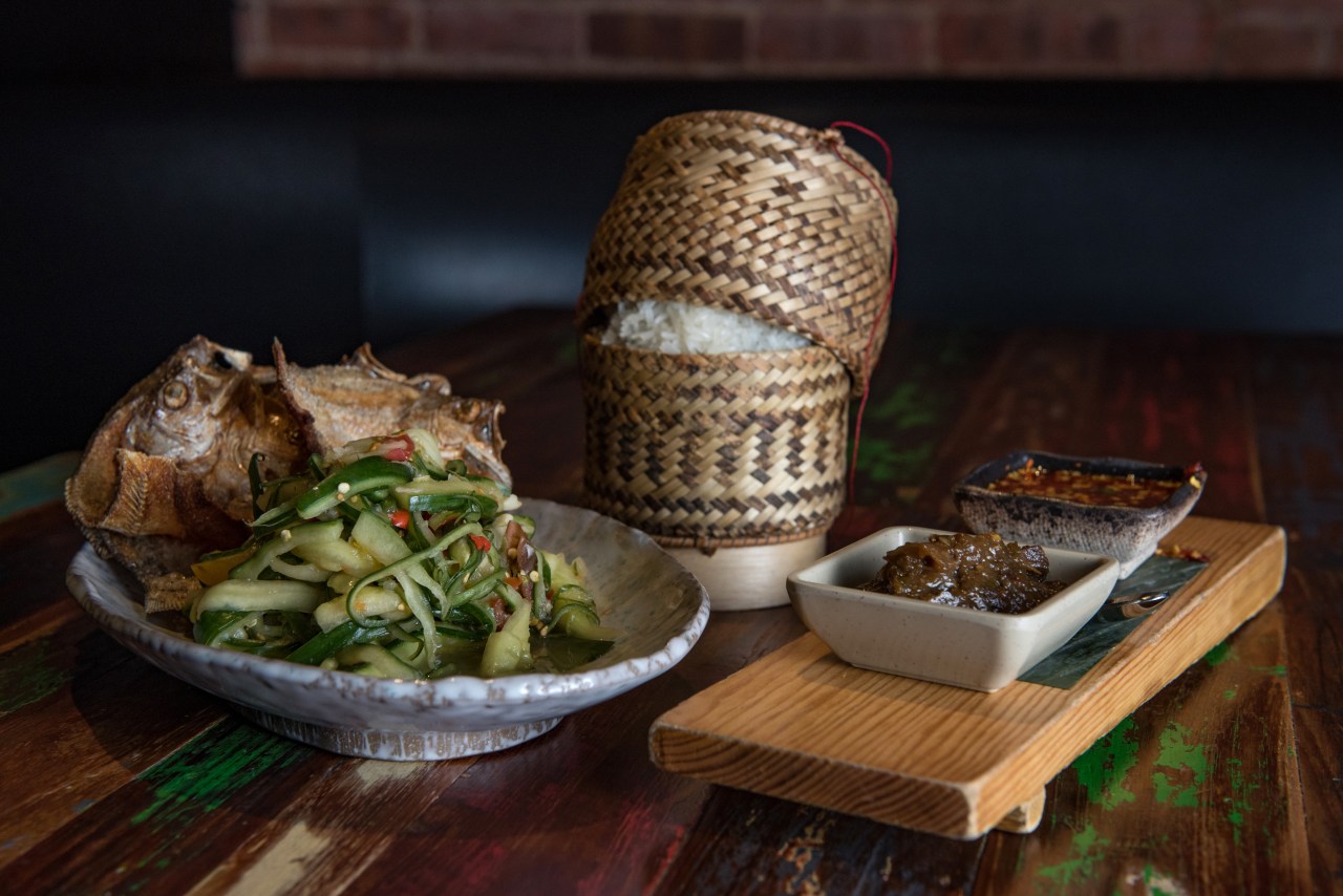 Smashed salad, crispy fish, and sticky rice served with eggplant and a spicy chili sauce.