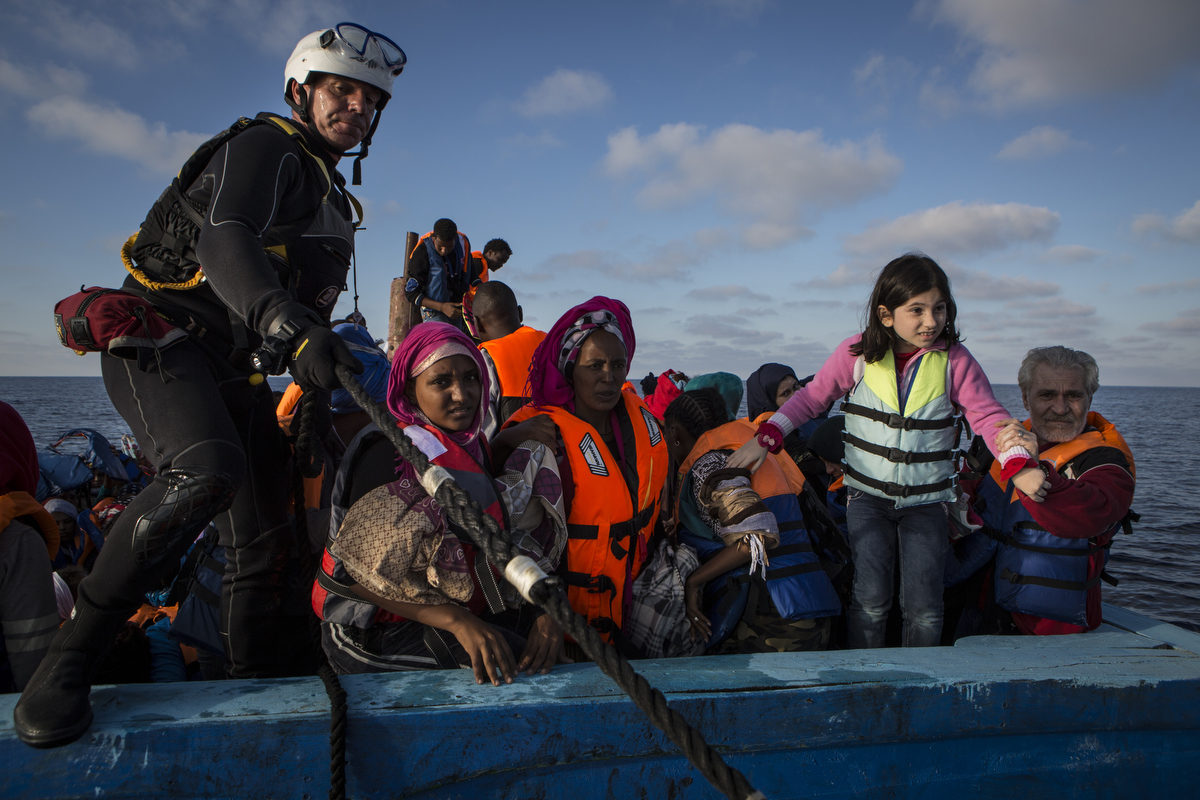 Rescue swimmer Jim onboard with Syrian and Eritrean migrants.