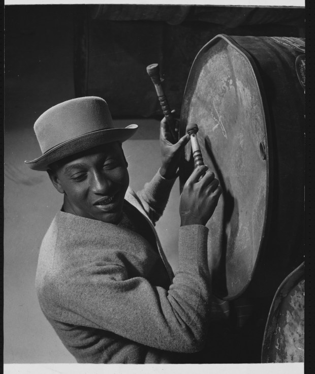 Dudley Smith, a member of a steel band from the West Indian island of Trinidad, tunes his boom and listens to check on the pitch. It is made from a large dustbin welded into several different parts. (Photo by © Hulton-Deutsch Collection/CORBIS/Corbis via Getty Images)