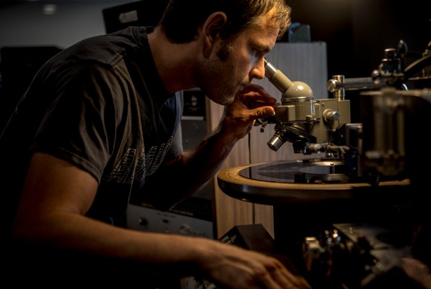 1. Wes Garland inspects a record. / 2. Jacob Moon, a quality control employee, watches and listens to a spinning record. Every 50th record is checked.