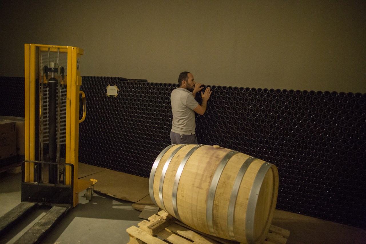 Walid Habshi, a farmer, member of the Heliopolis Cooperative and co-founder/partner in Couvent Rouge, inspects bottled wine in a huge cellar in the basement of the Couvent Rouge winery.