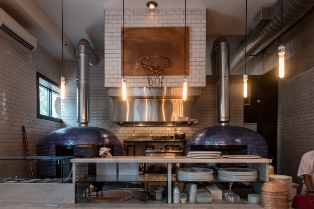 1. A brass basketball hoop sits over the pizza ovens. / 2. Photographs of Basquiat by Lee Jaffe.
