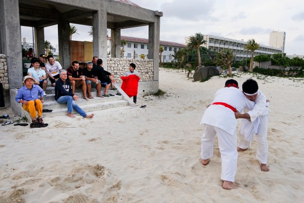 Bourdain watches Tegumi practice (Okinawan sumo wrestling) on Kume Island.