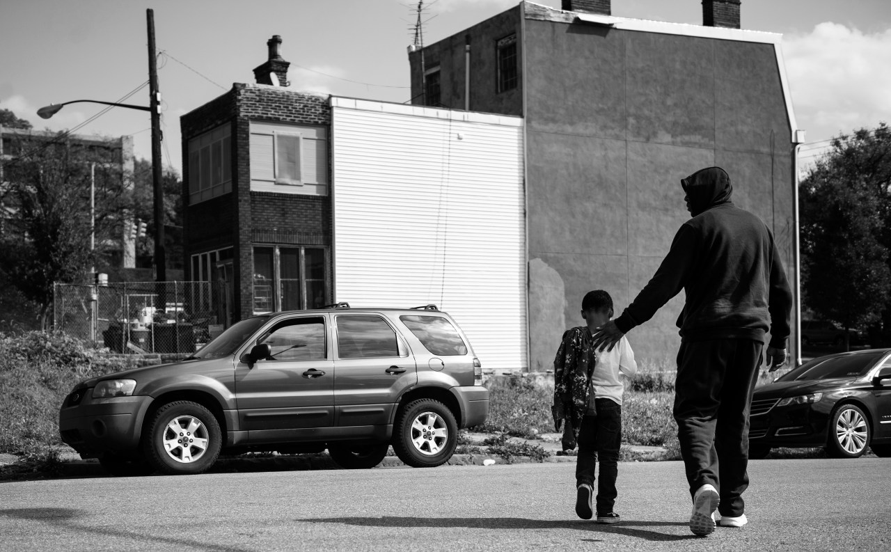 Chris Collins, walks his son Chris across the street after receiving his weekly haircut at Dave's Barber Shop. Between work and home life, the two share this trip as a special father and son moment.