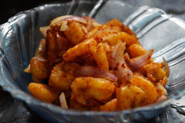 Prawn fry seasoned with masala, served with sliced red onion and a squeeze of lime.