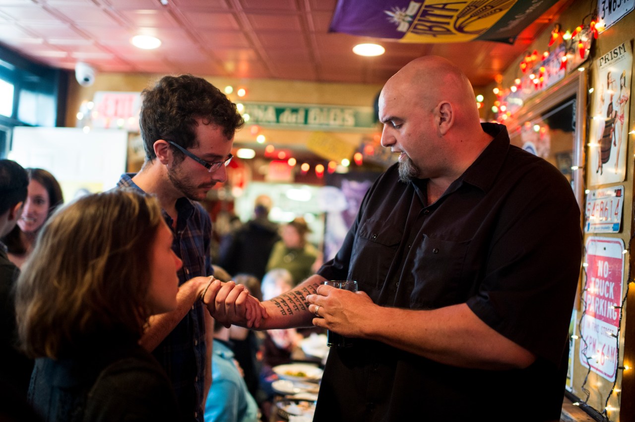 John Fetterman shows off his tattoos as he speaks with supporters during his meet and greet campaign stop at the Interstate Drafthouse in Philadelphia on Sunday, April 3, 2016. (Photo By Bill Clark/CQ Roll Call via Getty Images)