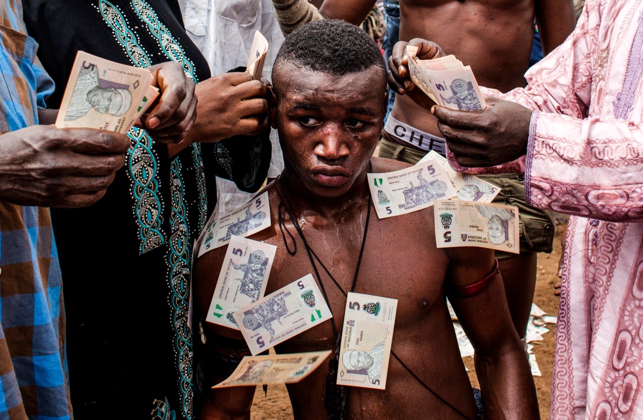 Boxer 'Shago' Sumula Alabo is "sprayed" with money after a match.