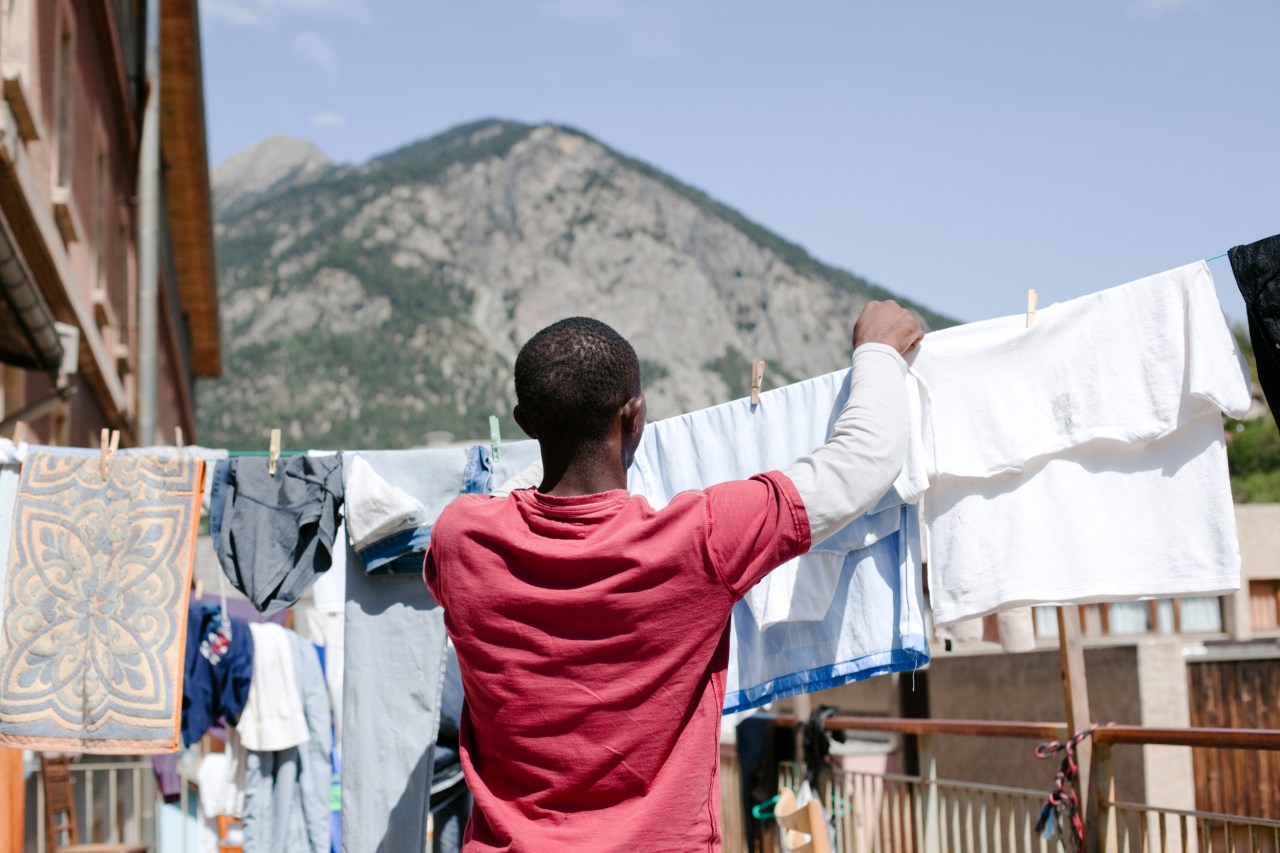 A migrant from Guinea hangs clothes out to dry on the terrace of the emergency shelter in Briançon.