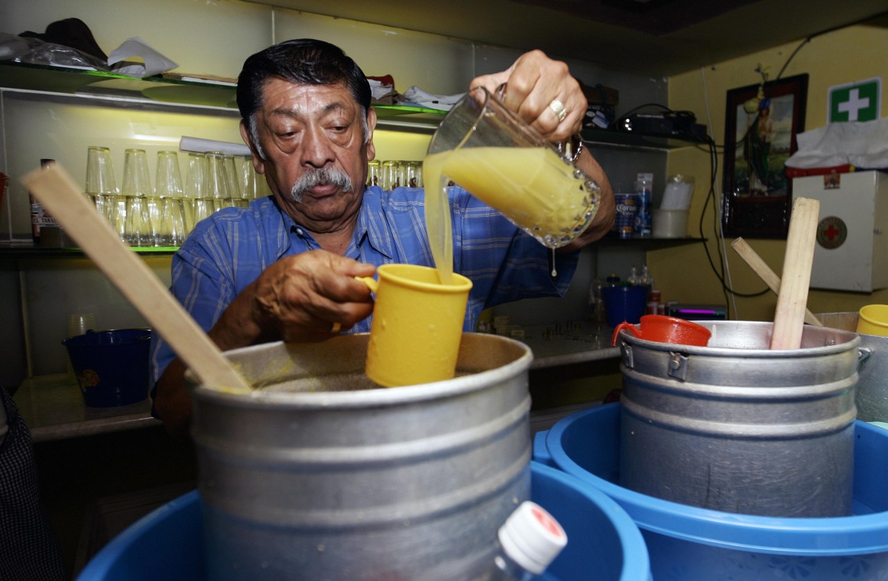Epifanio Leyva pours pineapple pulque. (Photo by Ronaldo Schemidt/AFP via Getty Images)