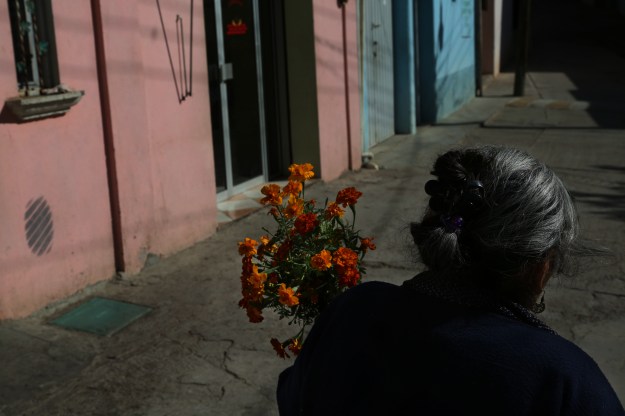 Photo 1: Teresa Raymundo walks to a funeral with a bundle of flowers in San Juan del Rio, Oaxaca, Mexico. Photo 2: The church in San Juan del Rio, Oaxaca, Mexico was built in the early 1800's.