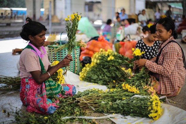 1. The station’s ill­-equipped security guards, police, and workers often also live at the station as part of their benefits./ 2. Women sort through fresh flowers that had just arrived at the station in the early morning.
