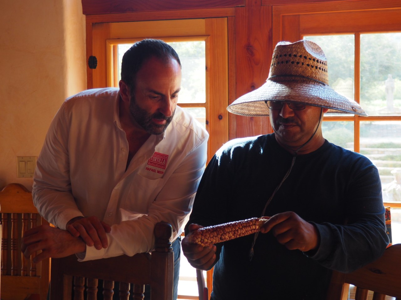 Rafael Mier showing an ear of corn to Salvador, the head farmer at Rancho la Puerta in Tecate, Mexico. (Photo by Jackie Bryant)