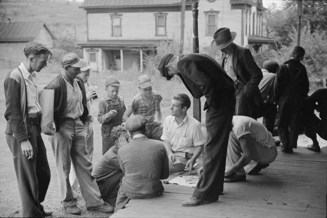 Coal miners gamble on the porch of the company store in Chaplin, September 1938. Photo by Marion Post Wolcott.