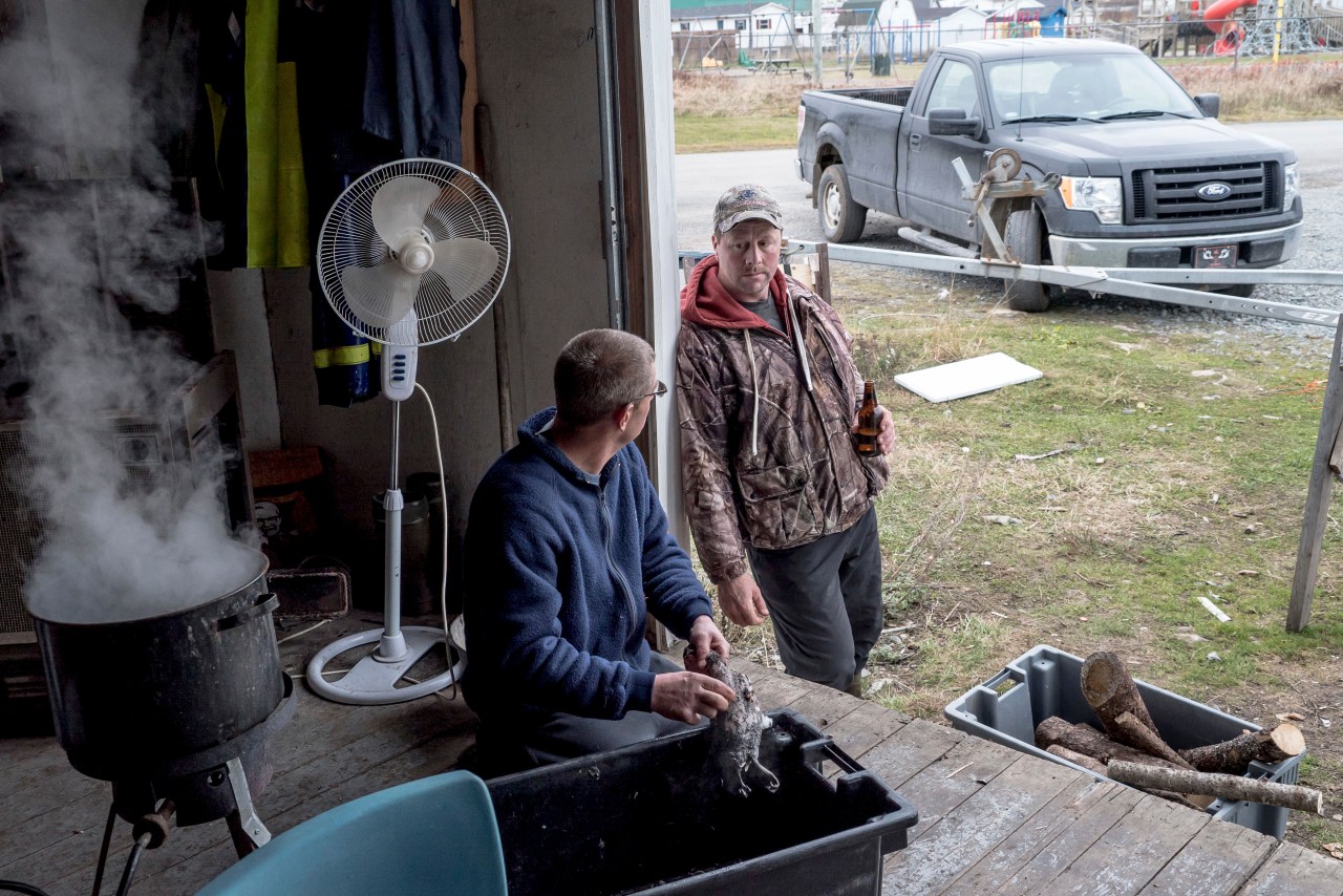 Shannon Mouland talks to a friend while cleaning his birds.