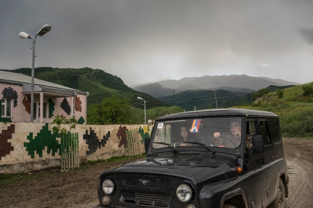 1. A soldier from the Nagorno-Karabakh armed forces at a front-line post near Talish. 2. A military jeep from the Nagorno-Karabakh armed forces approaches a base in Talish.