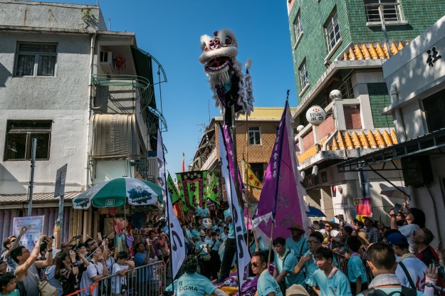 Visitors watch the Piu Sik (Floating Colors) Parade during the Bun Festival on Cheung Chau Island.