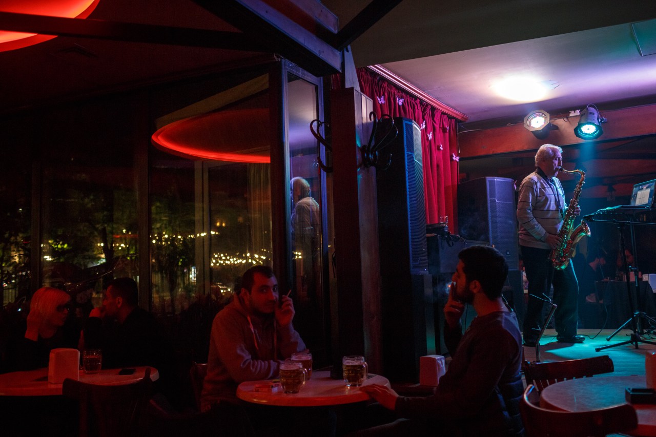 A local musician plays the saxophone at a restaurant in Yerevan.