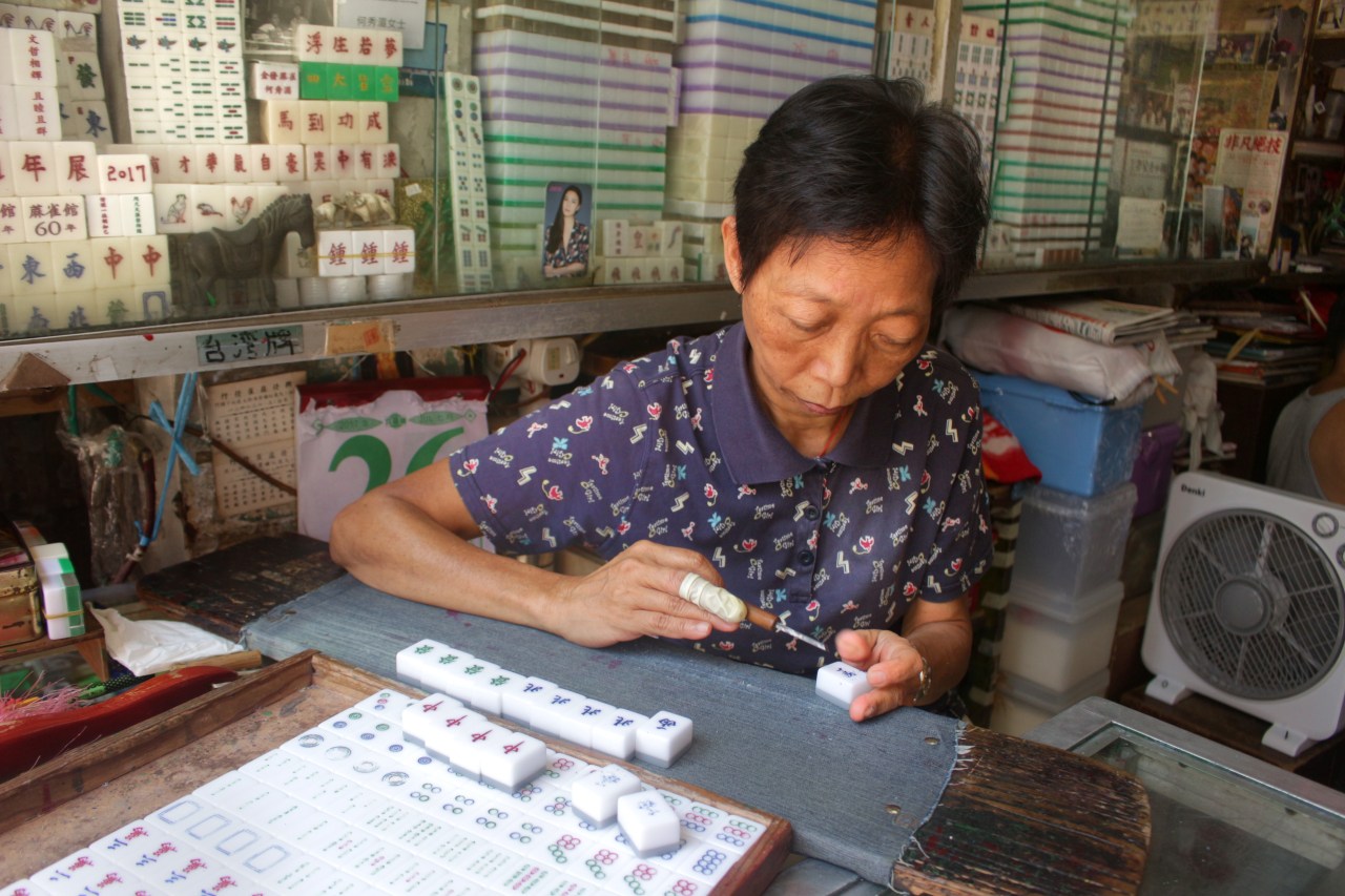 Ho Sau-mei carves the Chinese character for "west" onto a mahjong tile.