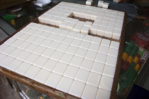 A tray of blank plastic mahjong tiles wait to be carved.