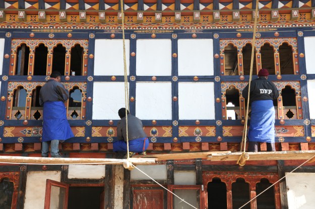 1: Painters touch up a temple in Paro. 2:  Buddhist prayer wheels at Kyichu Lhakhang Temple.