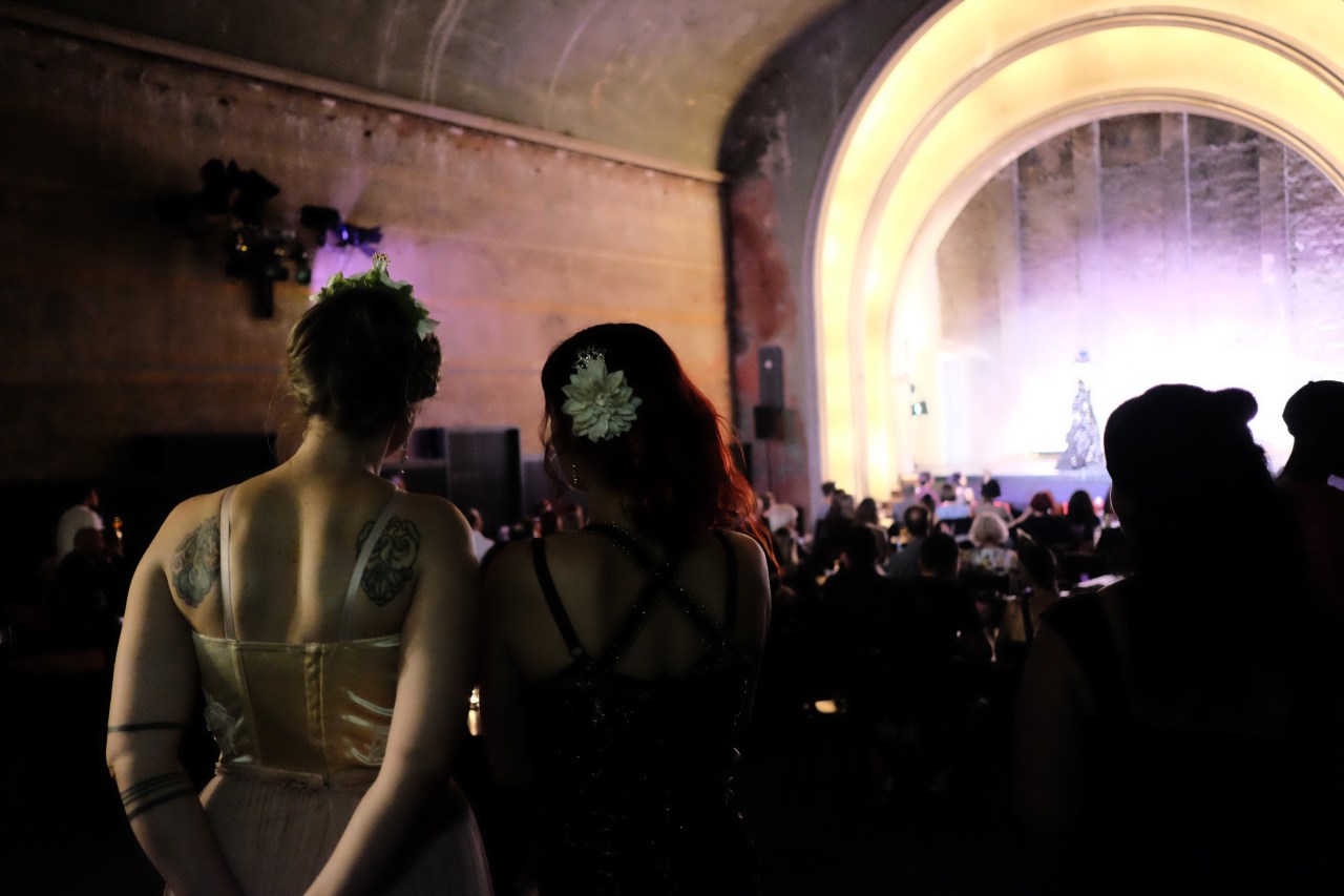 Two women watch a performance during the event.