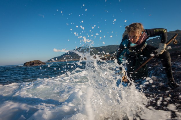 1. Isabel braces as a wave hits. 2. Lala checks between the rocks.