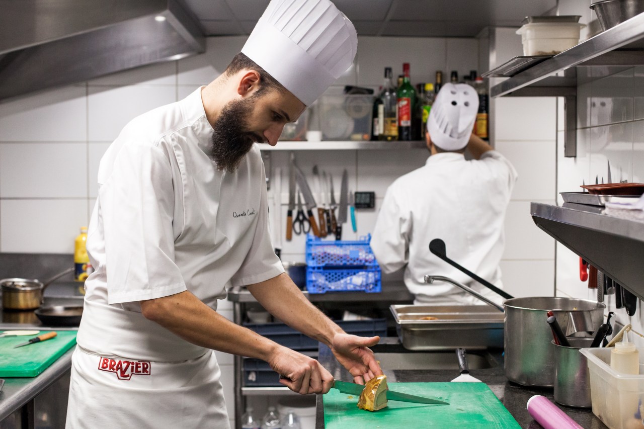 A chef cuts a fond d'artichaut au foie gras, a classic dish by Eugénie Brazier.