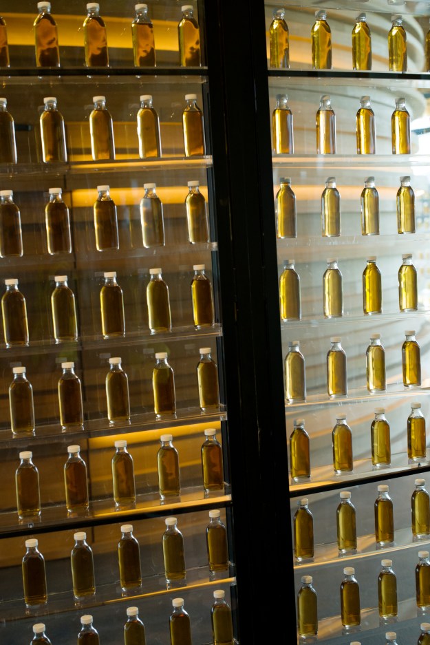 1: A bodega owner samples sherry. 2: Small bottles of whisky drawn from different casks displayed at The Macallan Distillery.