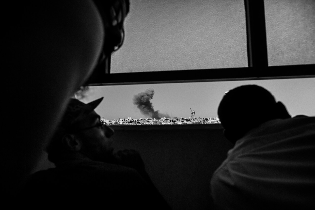 Members of the Libyan forces, affiliated with the Tripoli government, watch an airstrike on ISIS positions in Sirte - September 2016.