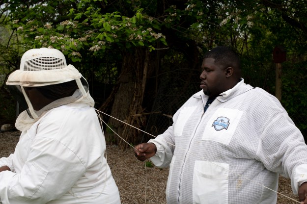 1: Jackson helps Lindsey adjust her bee suit. 2: Jackson lights the hive smoker, a tool to relax the bees before inspecting their hive.