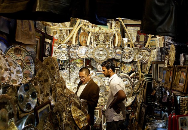 1: A tourist shops for souvenirs at a market in the old city of Tripoli. Photo by Joseph Eid/AFP via Getty Images. 2: Libyans shop for olives and pickles at a market in the center of the capital Tripoli. Photo by Mahmud Turkia/AFP/Getty Images.