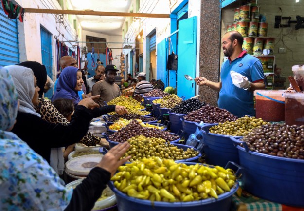 1: A tourist shops for souvenirs at a market in the old city of Tripoli. Photo by Joseph Eid/AFP via Getty Images. 2: Libyans shop for olives and pickles at a market in the center of the capital Tripoli. Photo by Mahmud Turkia/AFP/Getty Images.